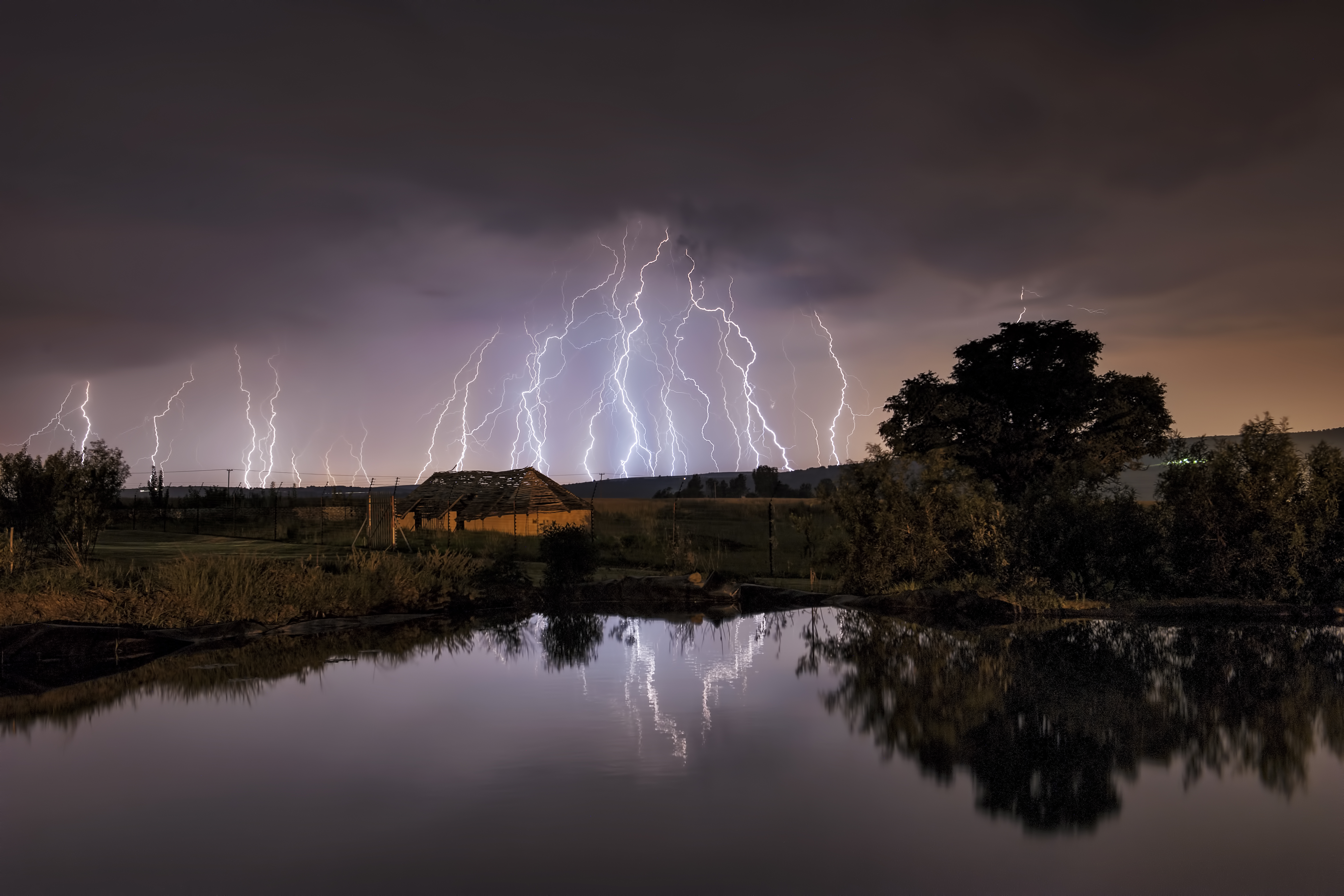 Lightning strikes over abandoned farm house and dam, Magaliesburg, Gauteng Province, South Africa