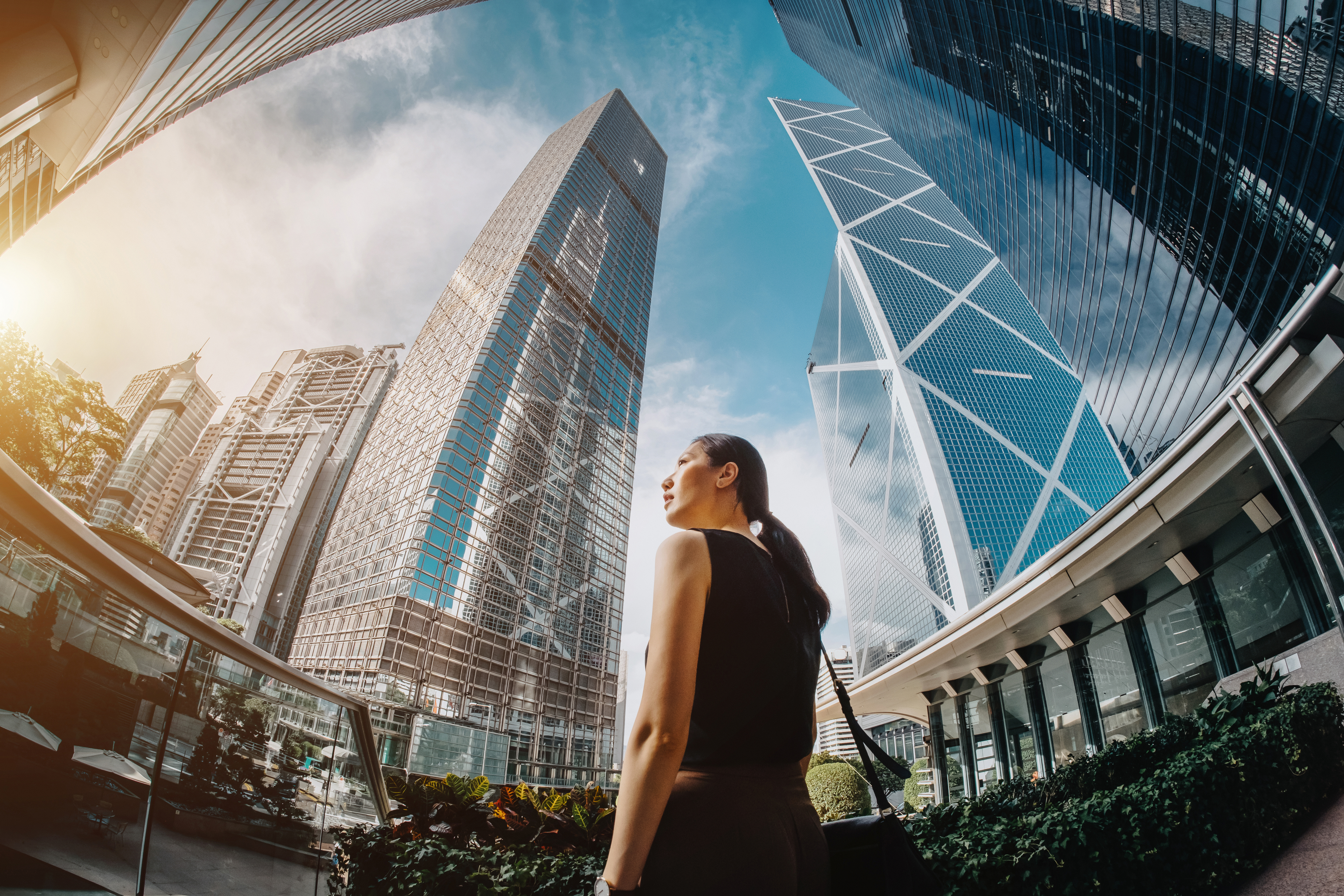 Asian businesswoman looking at highrise towers